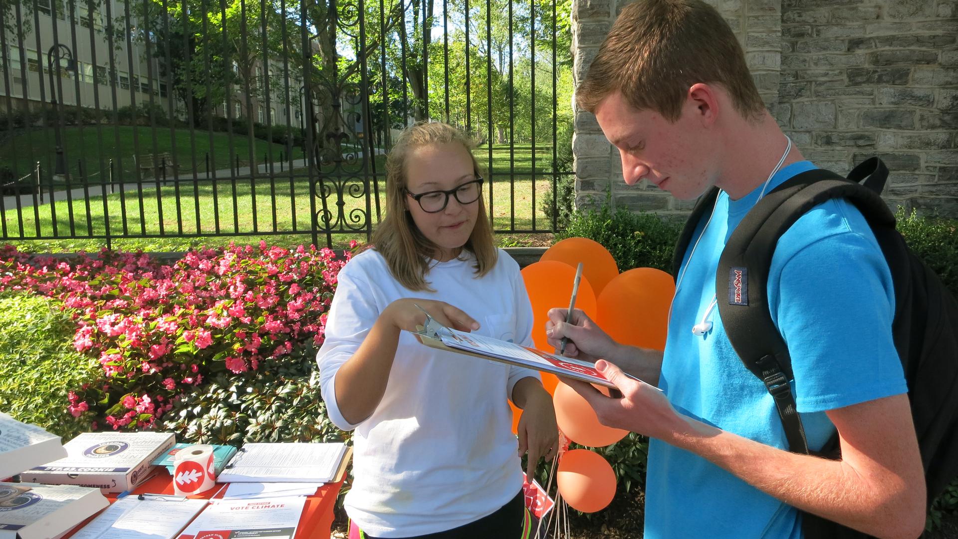 Penn State senior Makealy Meyers with NextGen Climate registers a potential voter just off campus and gets him to sign a commitment card to vote for a candidate who will tackle climate change. 