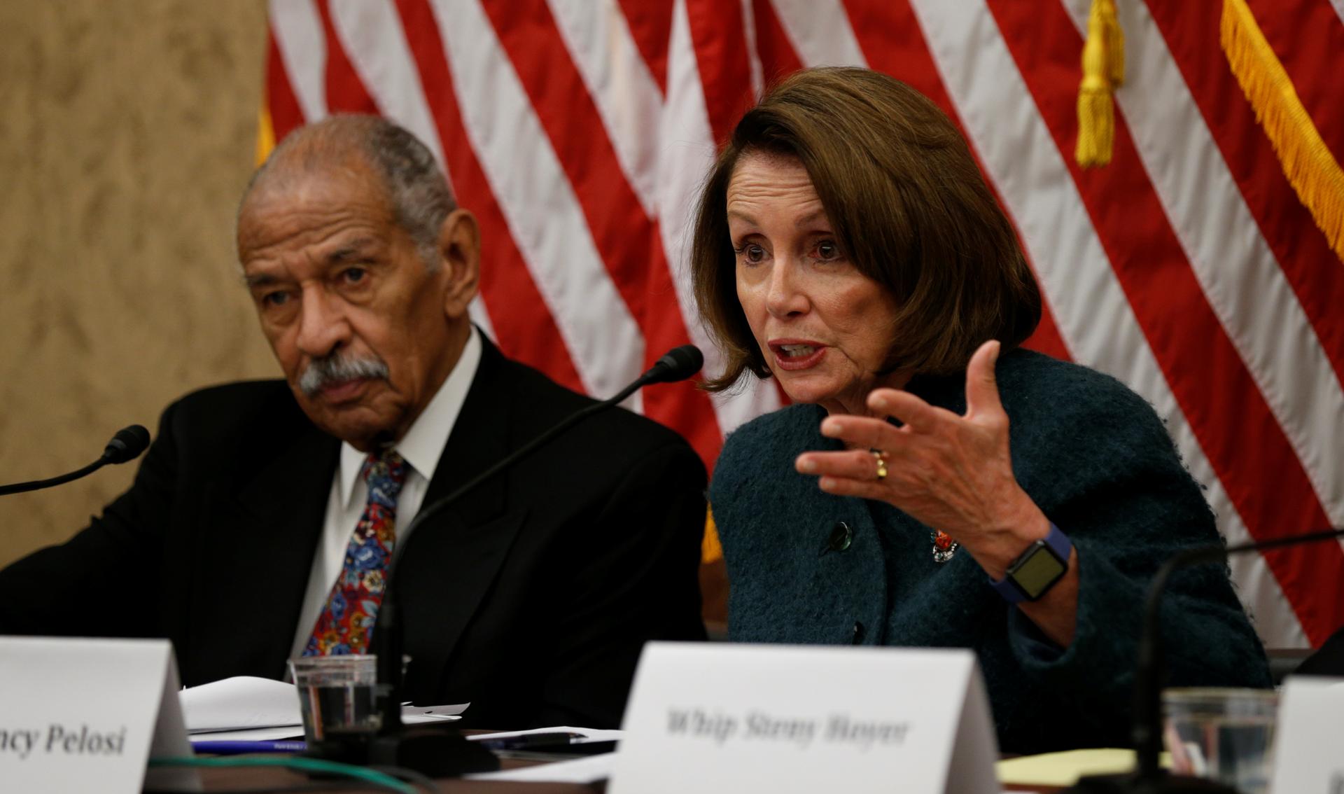 House Minority Leader Nancy Pelosi and Representative John Conyers sit side by side on a panel about Trump's visa ban on February 2, 2017.