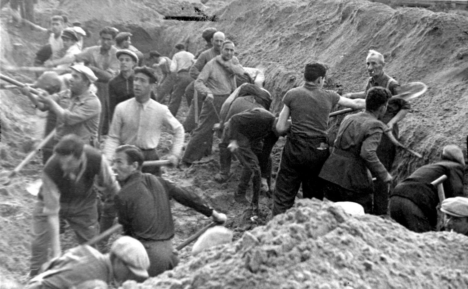 Jews digging a trench in Ponar forest, in which they were later buried, after being shot