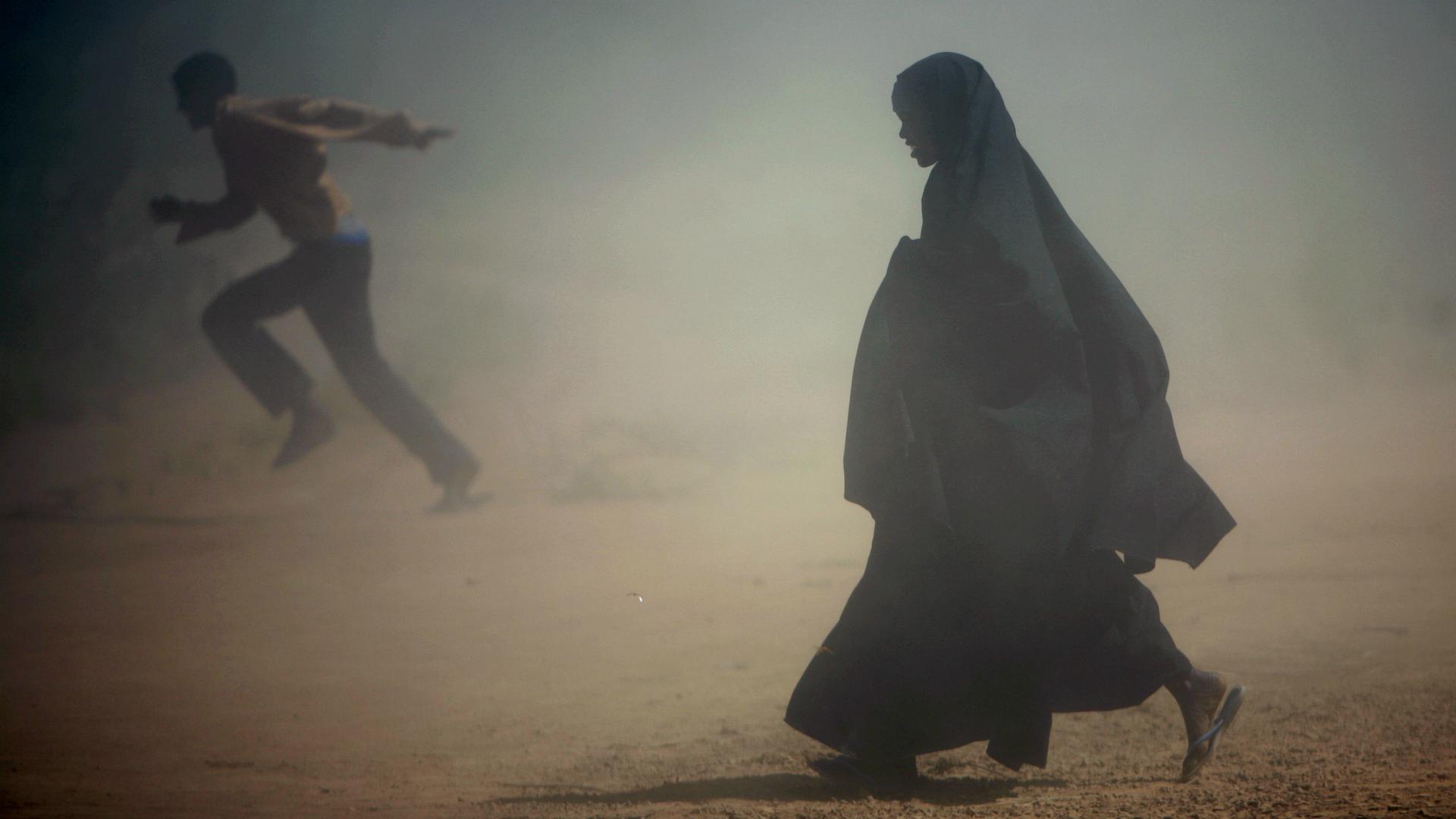 Somali refugees run from the dust at Dadaab's Ifo camp, Jan. 8, 2007.
