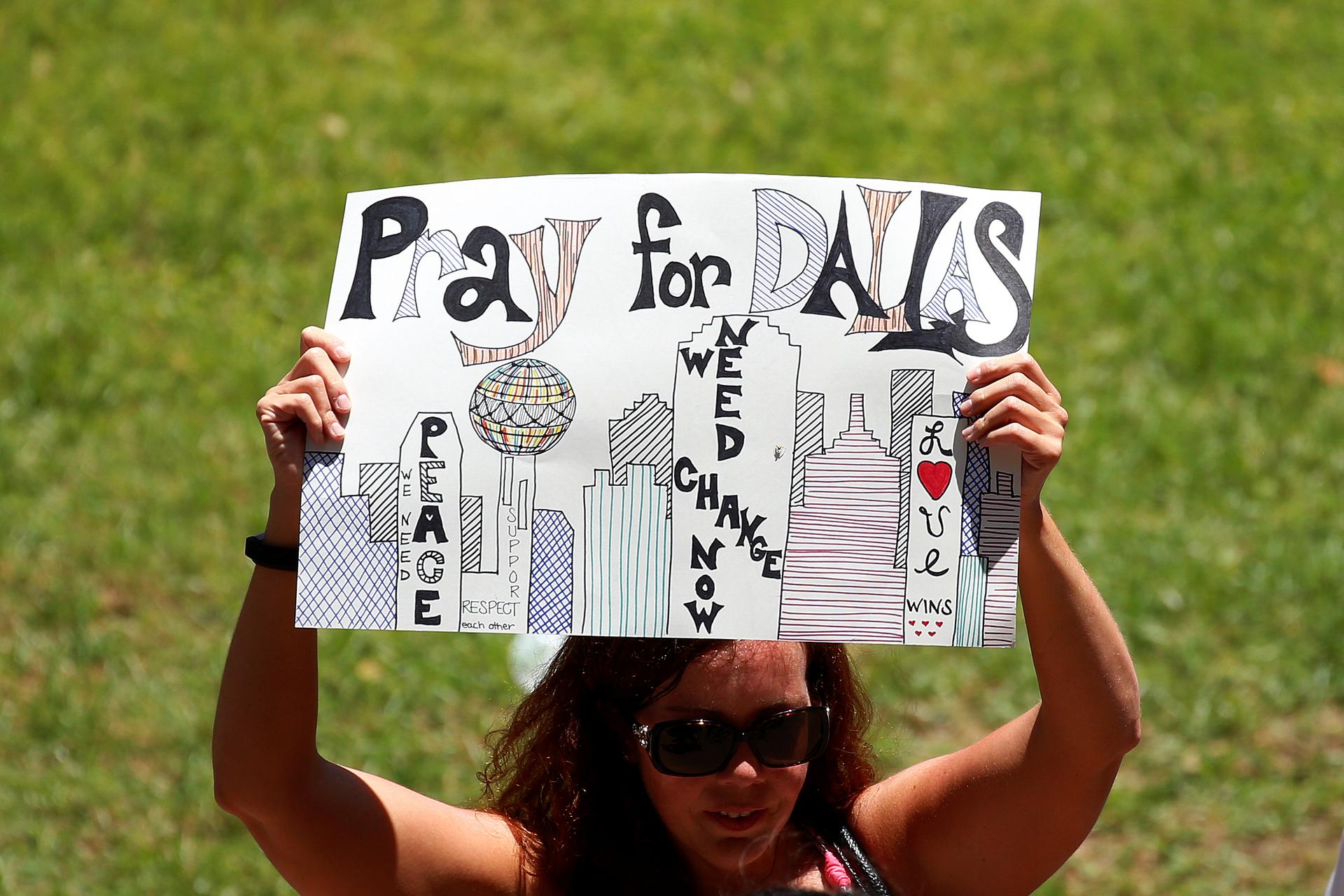 A woman holds up a sign of support during a prayer vigil 