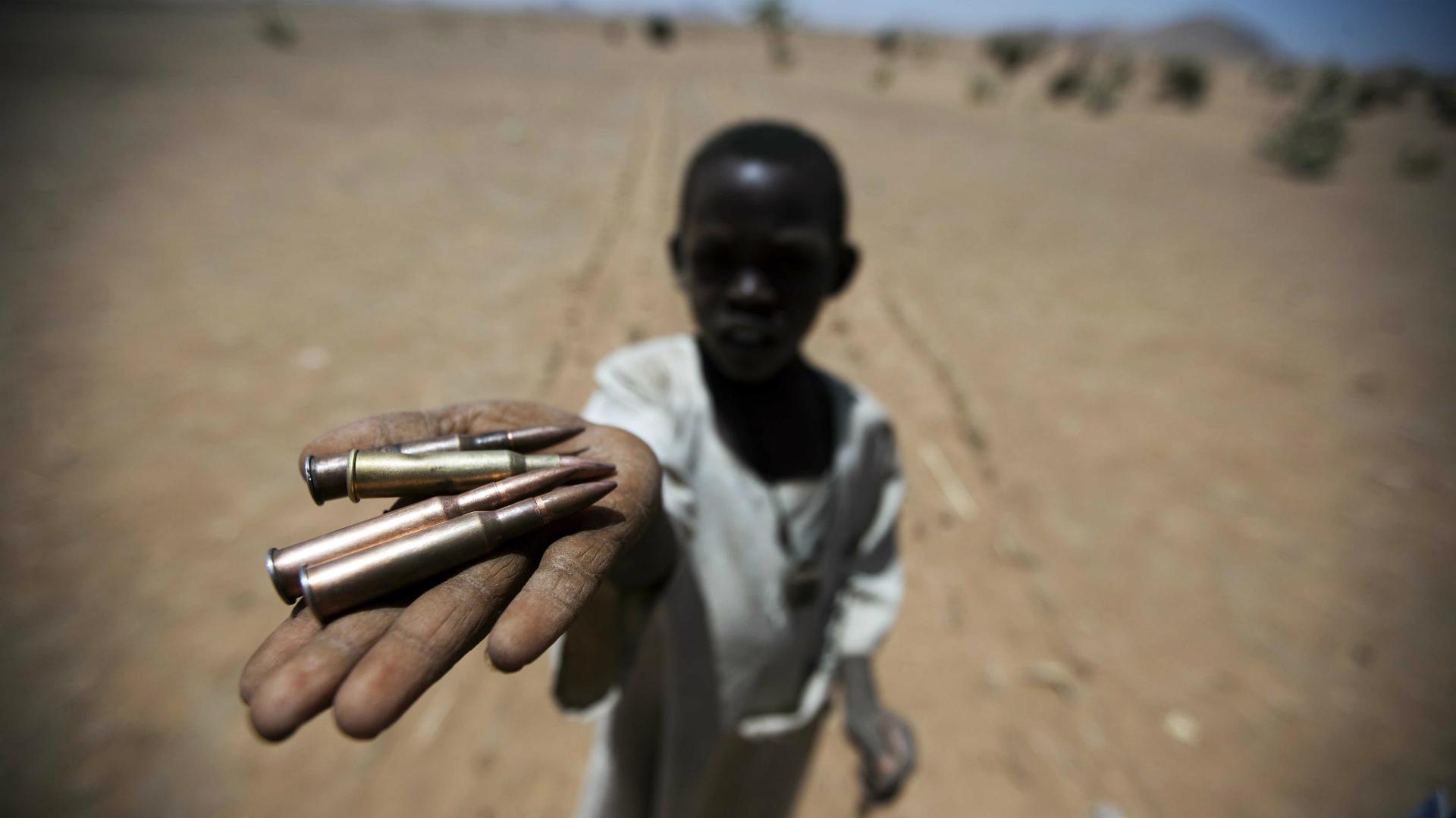 A child holds bullets picked from the ground, in Rounyn, a village located about 15 kilometers north of Shangil Tobaya, North Darfur, Sudan, on March 27, 2011.