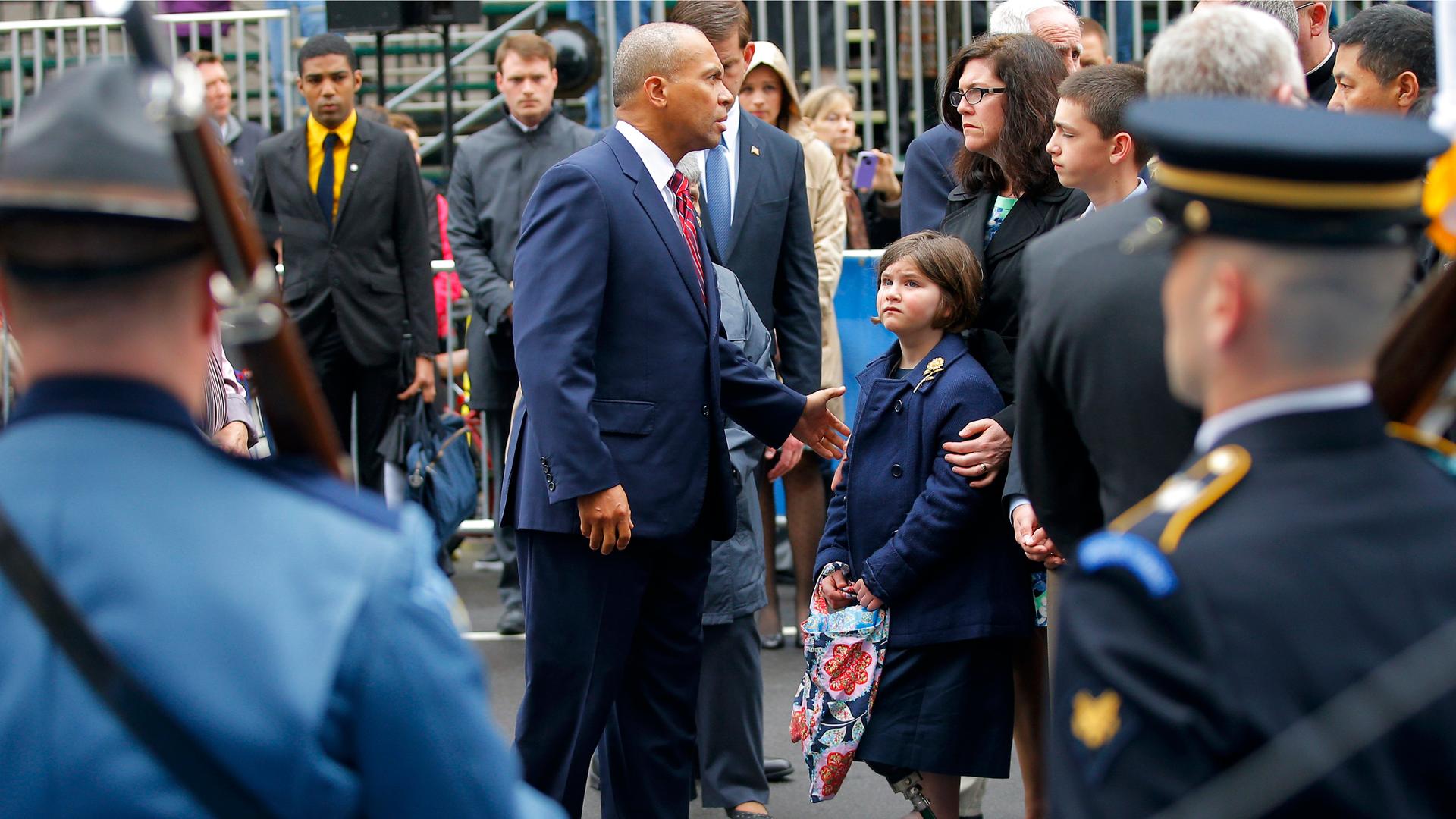 Massachusetts Governor Deval Patrick (C) joins the family of Boston Marathon bombing victim Martin Richard at the finish line for a wreath-laying ceremony in Boston, Massachusetts April 15, 2014. Richard's family members include sister Jane (3rd R), mothe