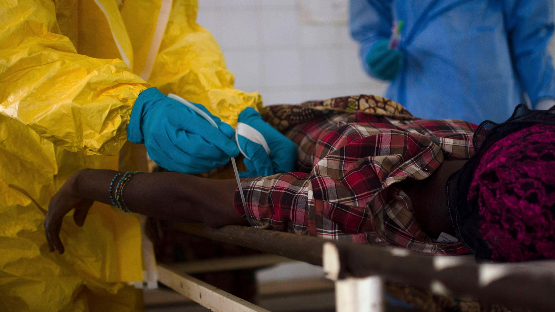 Medical staff take a blood sample from a suspected Ebola patient at the government hospital in Kenema, July 10, 2014. 