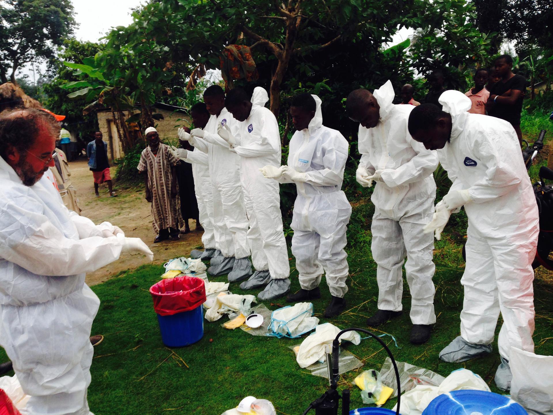 Volunteers prepare to remove the bodies of people who were suspected of contracting Ebola and died in the community in the village of Pendebu, north of Kenema July 18, 2014.