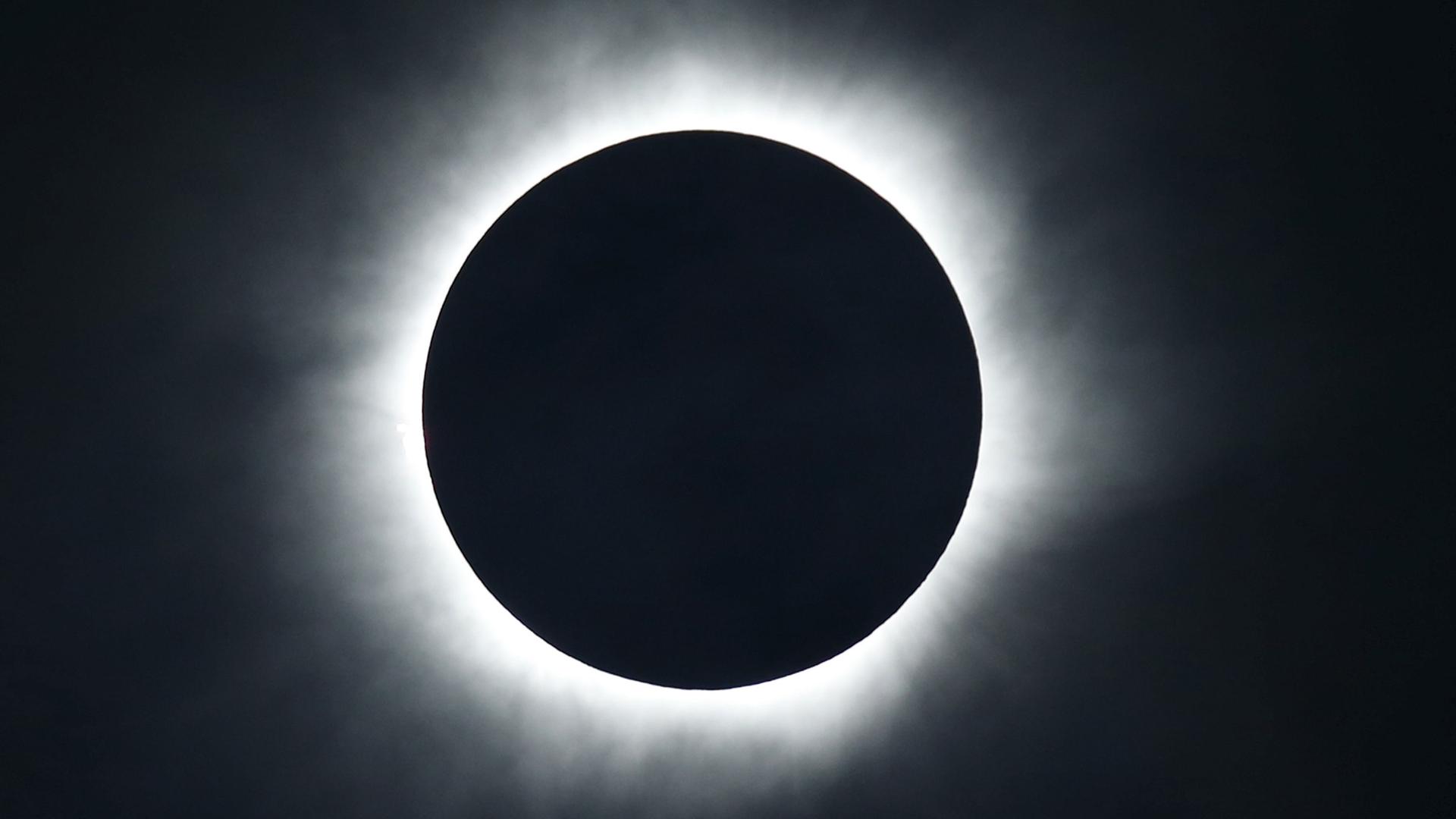 The sun is blacked out and surrounded by a ring of bright light during a total solar eclipse.