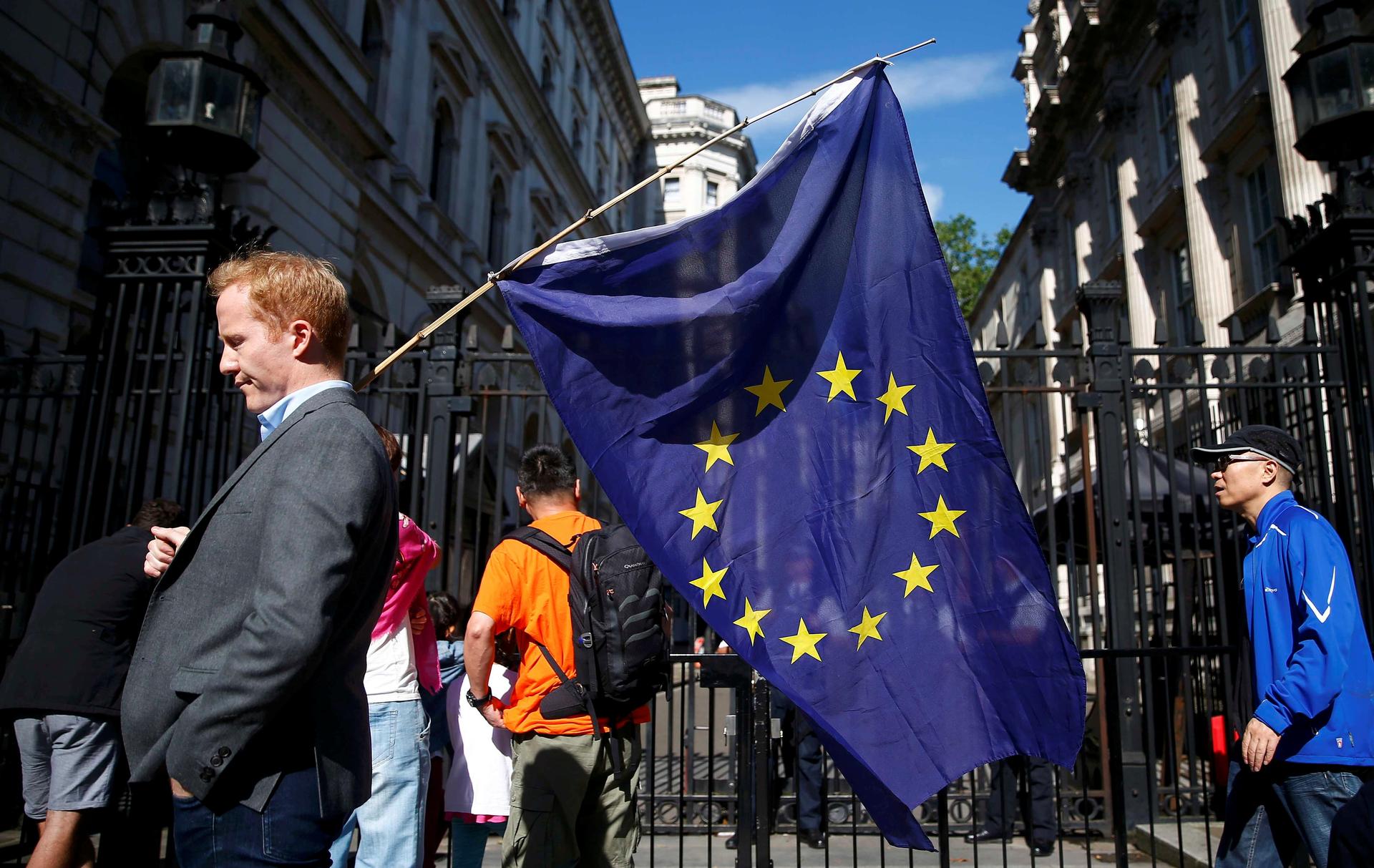 A man carries an EU flag after Britain voted to leave the European Union, outside Downing Street in London. 