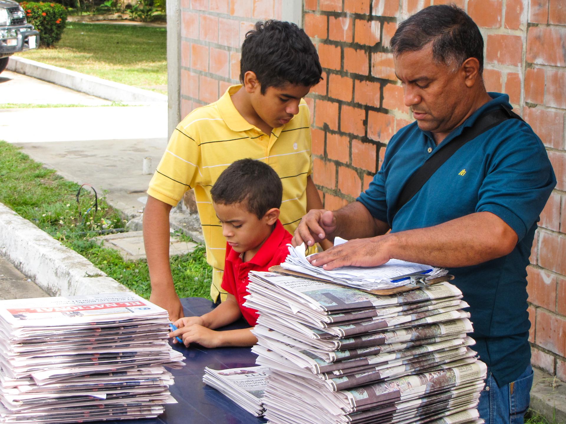 Jose Luis Farrera (with his sons) runs a newsstand in Venezuela. But business is down, because he can't get enough newspapers.  