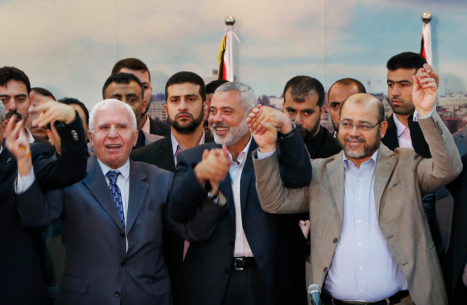 Senior Fatah official Azzam Al-Ahmed, left, head of the Hamas government Ismail Haniyeh, center, and senior Hamas leader Moussa Abu Marzouq announce a reconciliation agreement in Gaza City April 23, 2014.