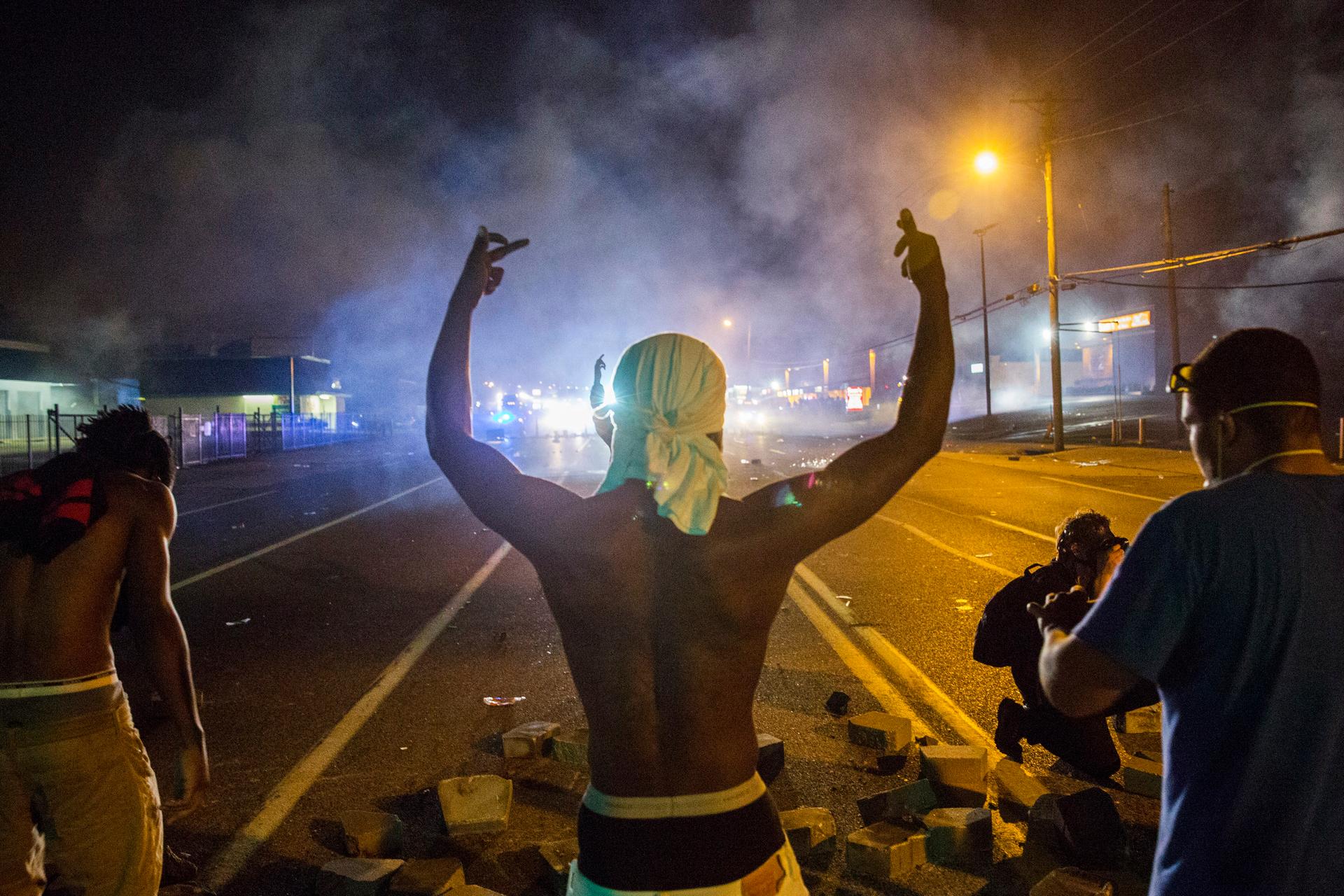 Demonstrators face off with police after tear gas was fired at protesters reacting to the shooting of Michael Brown in Ferguson, Missouri August 17, 2014. 