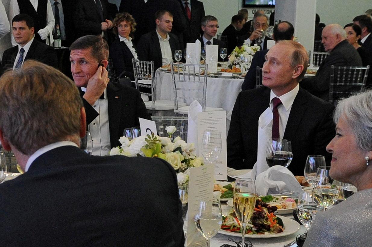 Russian President Vladimir Putin, right, sits next to retired US Army Lt. Gen. Michael Flynn