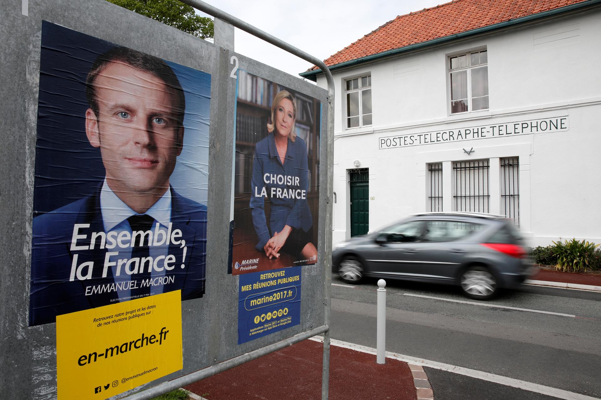 Official posters of the candidates for the 2017 French presidential election, Emmanuel Macron, left, head of the political movement En Marche!, or Onwards!, and Marine Le Pen, of French National Front (FN).