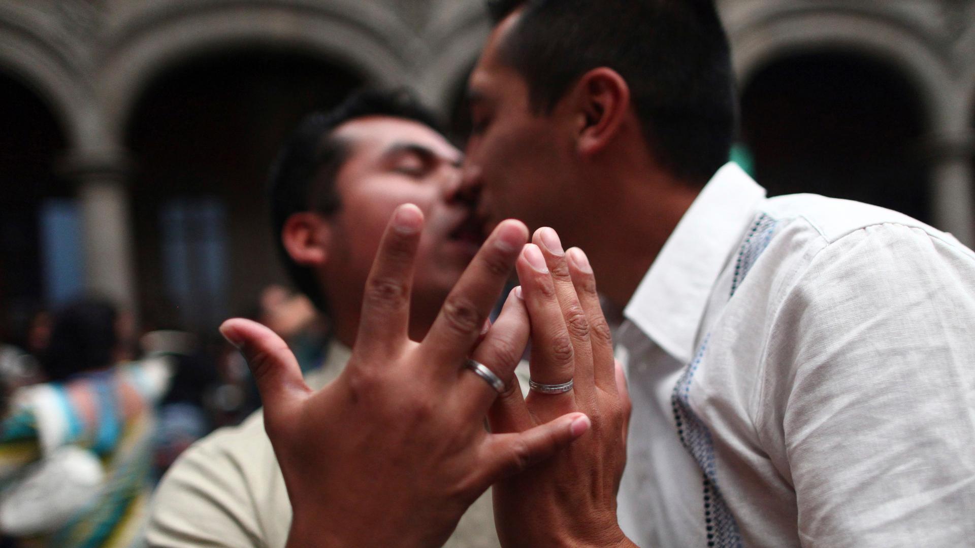 A gay couple kisses as they display their rings during a mass wedding in Mexico City on March 21, 2014. The ceremony commemorated the fourth anniversary of Mexico's legalization of same-sex marriage.