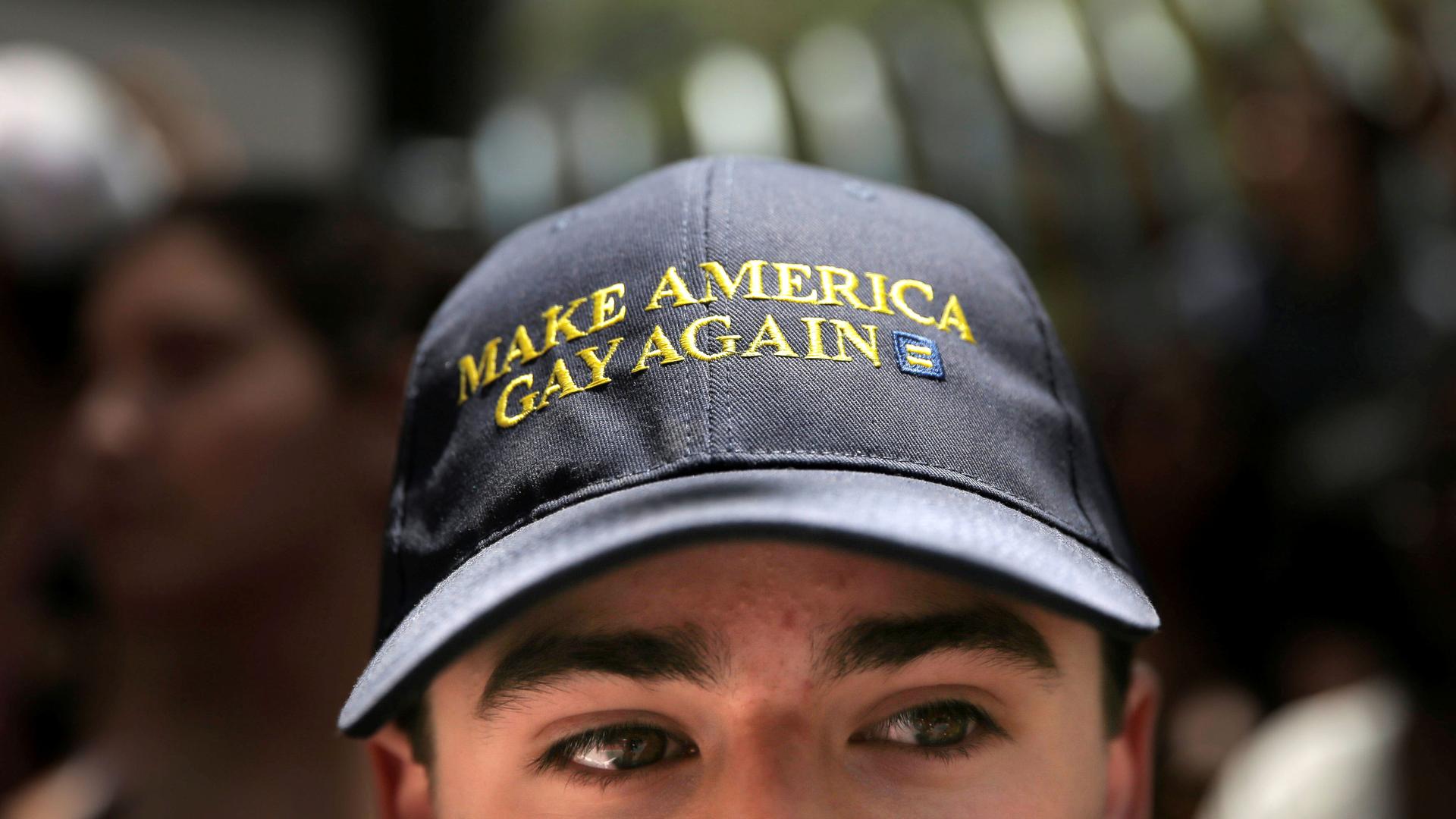 A man wears a Make America Gay Again hat.