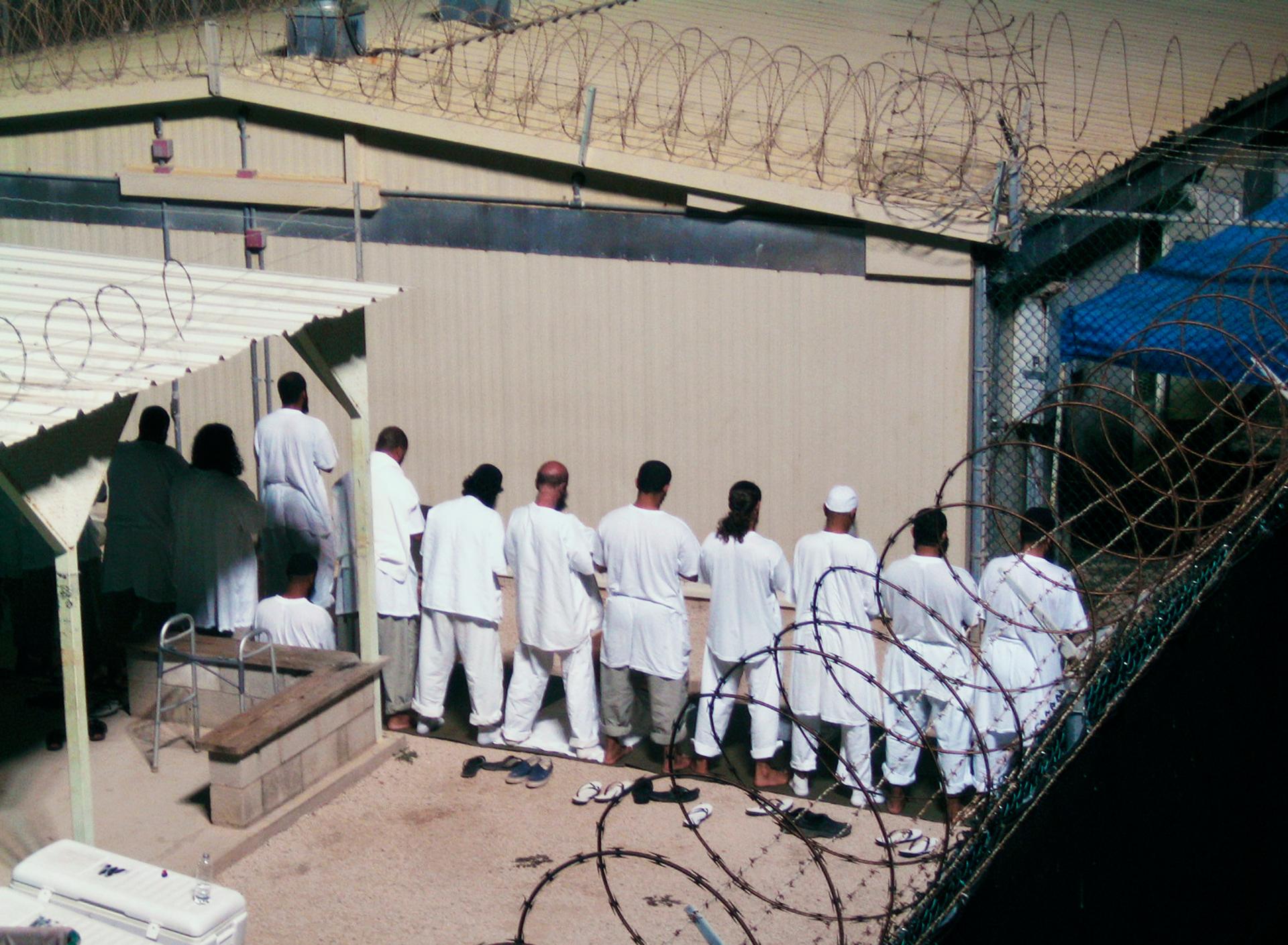 Detainees participate in an early morning prayer session at Camp IV at the detention facility in Guantanamo Bay