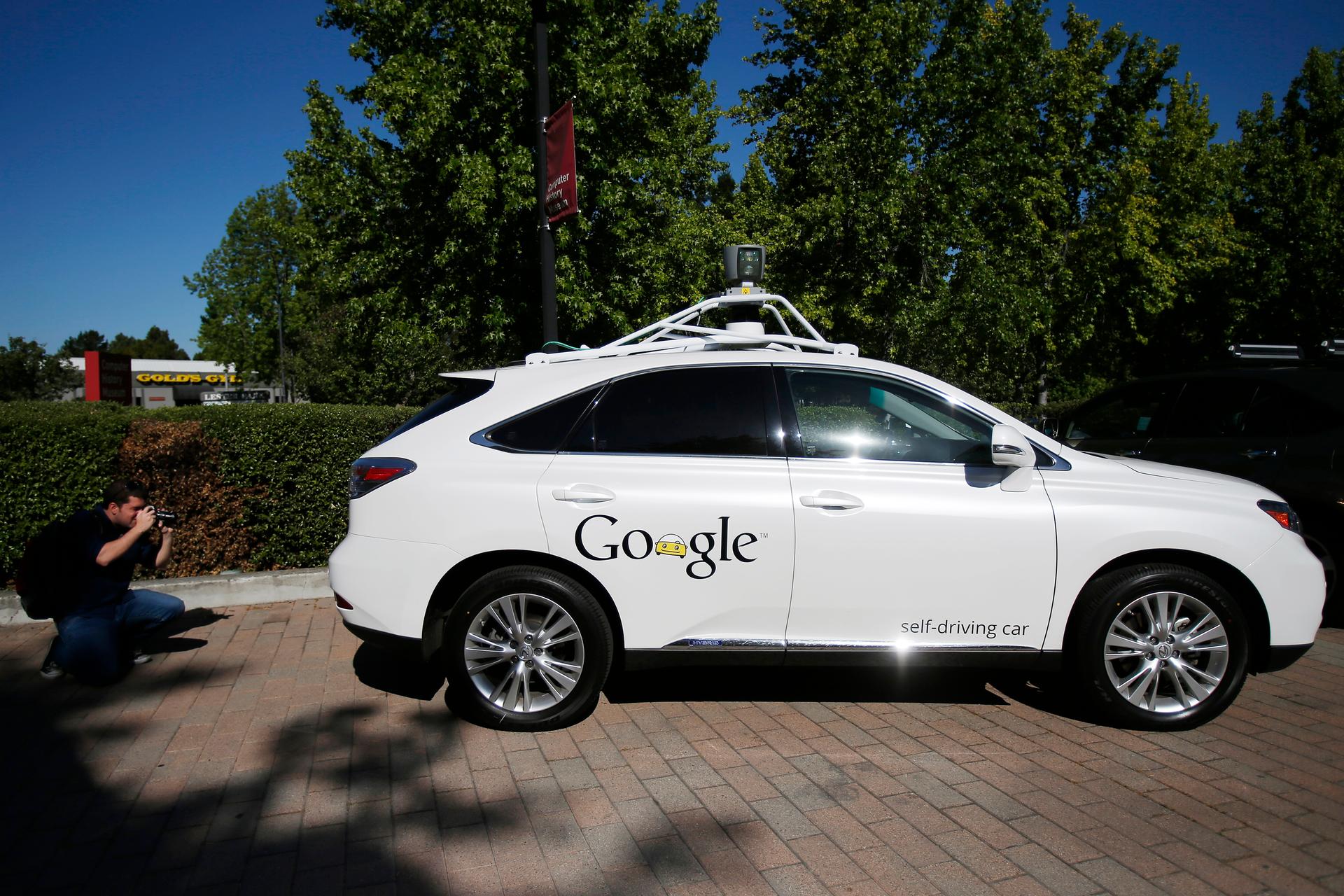 An attendee takes a photograph of the Google self-driving vehicle outside the Computer History Museum in Mountain View, California May 13, 2014. 
