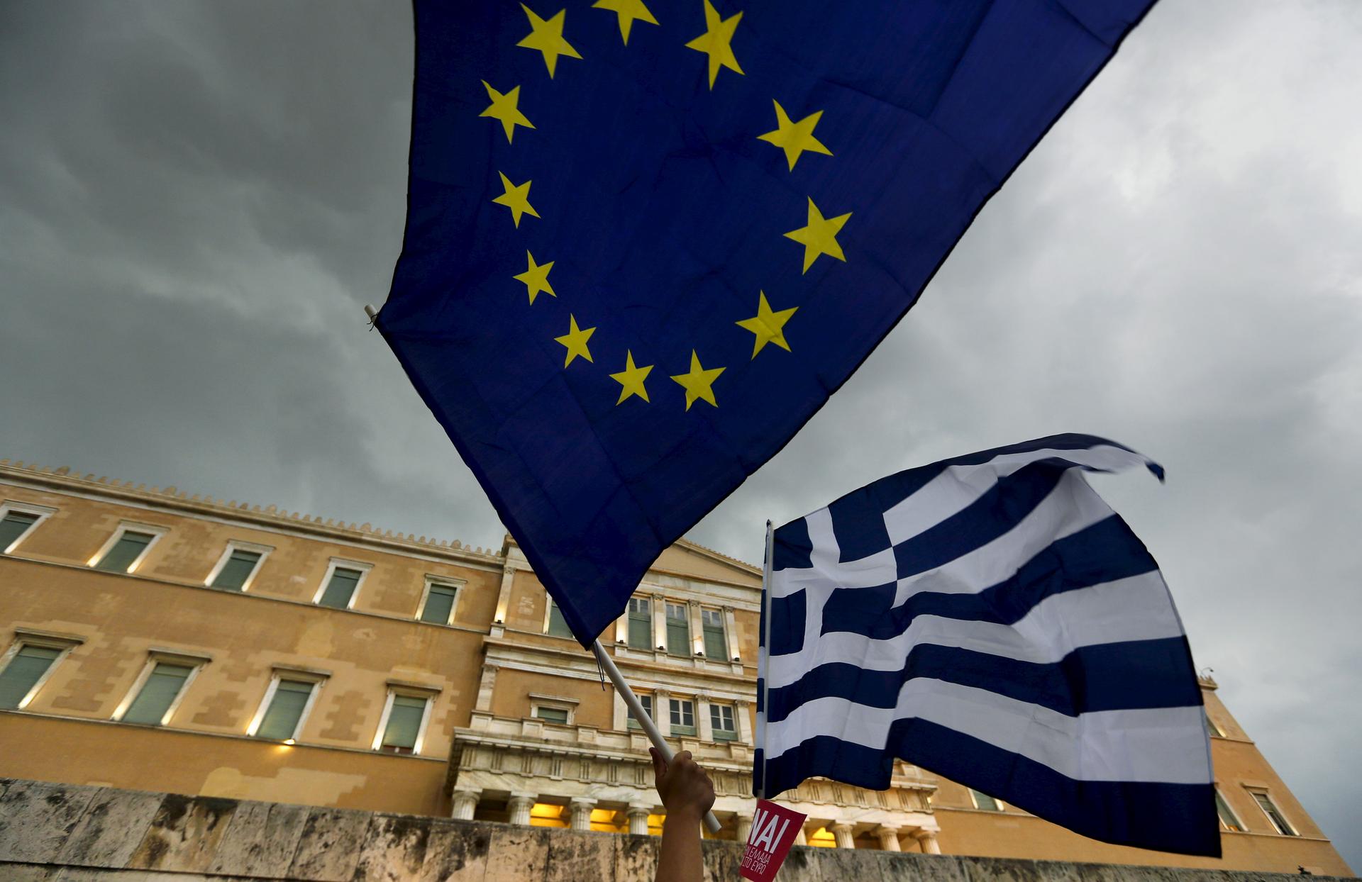 Two flags - one for Greece and one for the EU - fly during protests in Athens this week