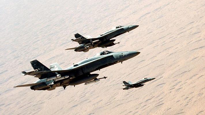 Three U.S. Navy McDonnell Douglas F/A-18C Hornet fighters from strike fighter squadron VFA-83 Rampagers fly in formation over the desert during "Operation Desert Storm" on 3 February 1991.
