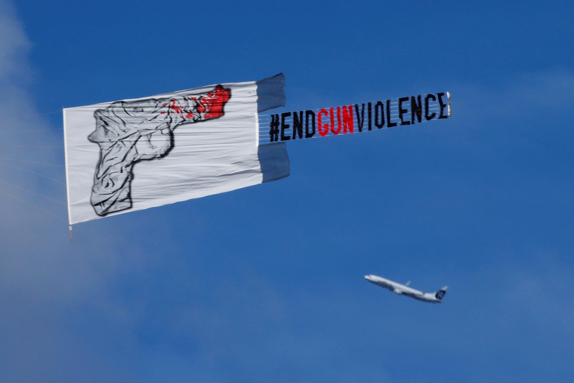 A plane pulls a banner that reads "#End Gun Violence" over a vigil for the Pulse night club victims
