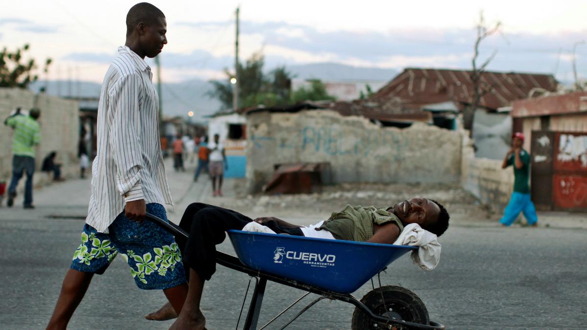 A Haitian with symptoms of cholera is transported in a wheelbarrow
