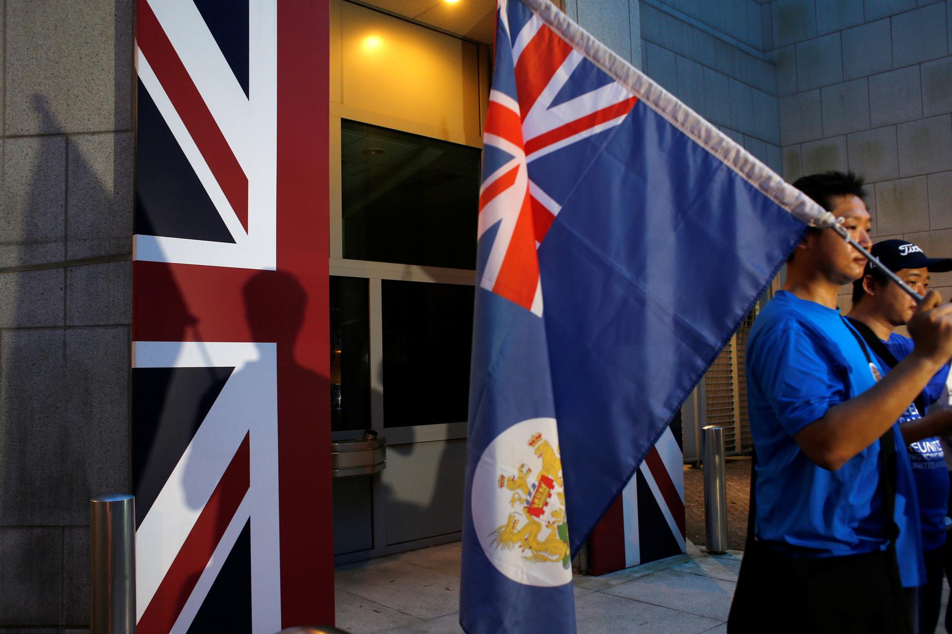 A campaigner carries a former colonial Hong Kong flag during a Hong Kong-UK reunification demonstration outside the British Consulate in Hong Kong on July 1, 2016, the 19th anniversary of Hong Kong's handover to Chinese sovereignty from British rule.