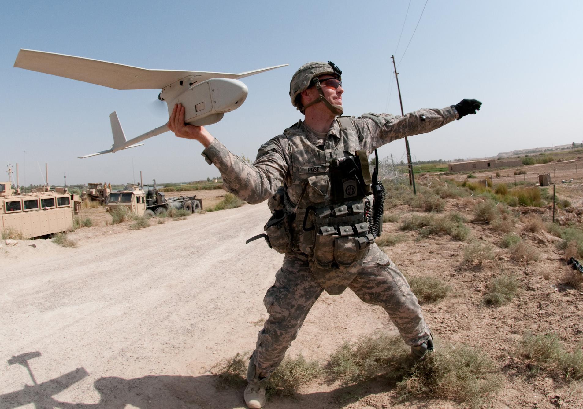 Army 1st Lt. Steven Rose launches an RQ-11 Raven unmanned aerial vehicle near a highway bridge project along the Euphrates River north of Taqqadum, Iraq.
