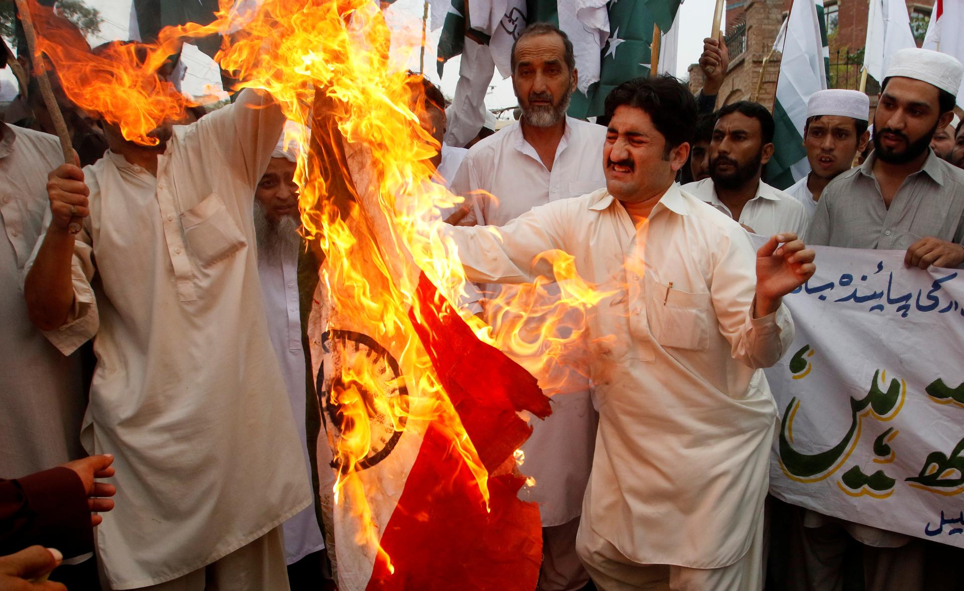 Pakistani protesters burn an Indian flag