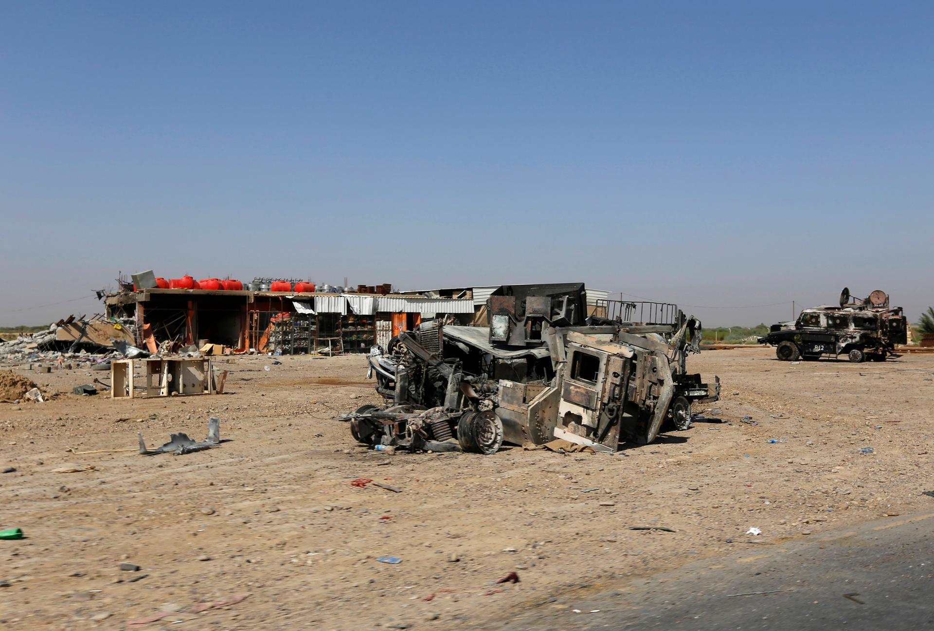 Burnt vehicles belonging to the Iraqi security forces are seen on a road leading to Samarra at Salahuddin province July 12, 2014.