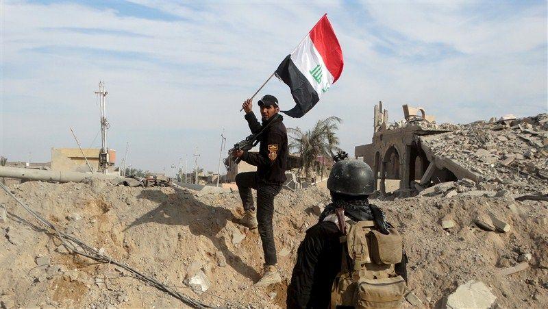 A member of the Iraqi security forces holds an Iraqi flag in the city of Ramadi. 