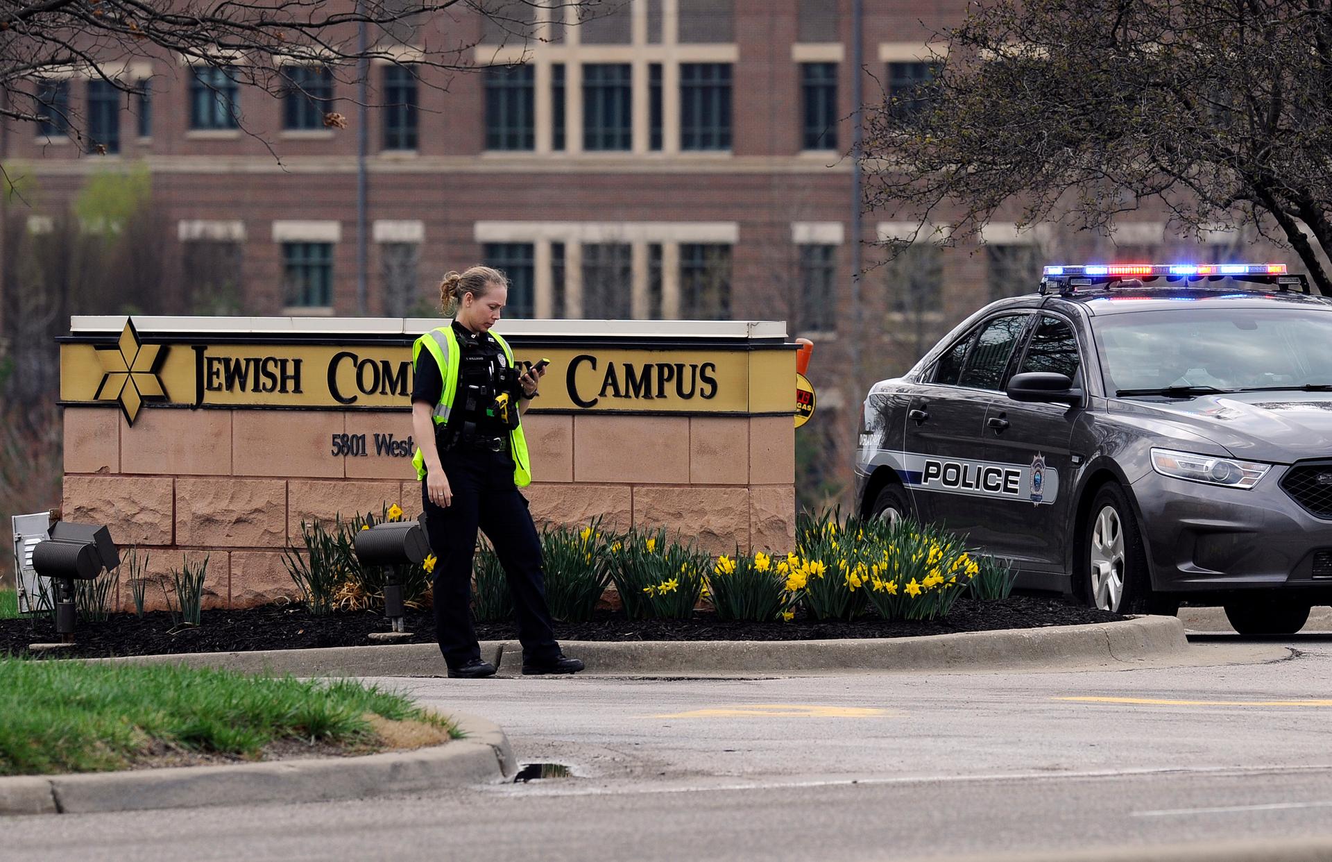 An Overland Park, Kansas, police officer guards the entrance to the scene of a shooting at the Jewish Community Center of Greater Kansas City in Overland Park, Kansas April 13, 2014. Three people were killed in shootings at Jewish centers in Kansas on Sun