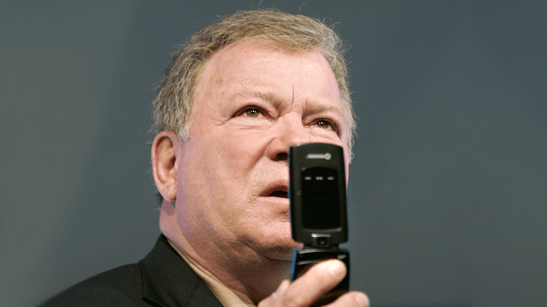 William Shatner, in a pose similar to his Star Trek character Captain Kirk using his communicator, unveils North America's first real-time video conferencing cell phone during a news conference in Toronto April 2, 2007.