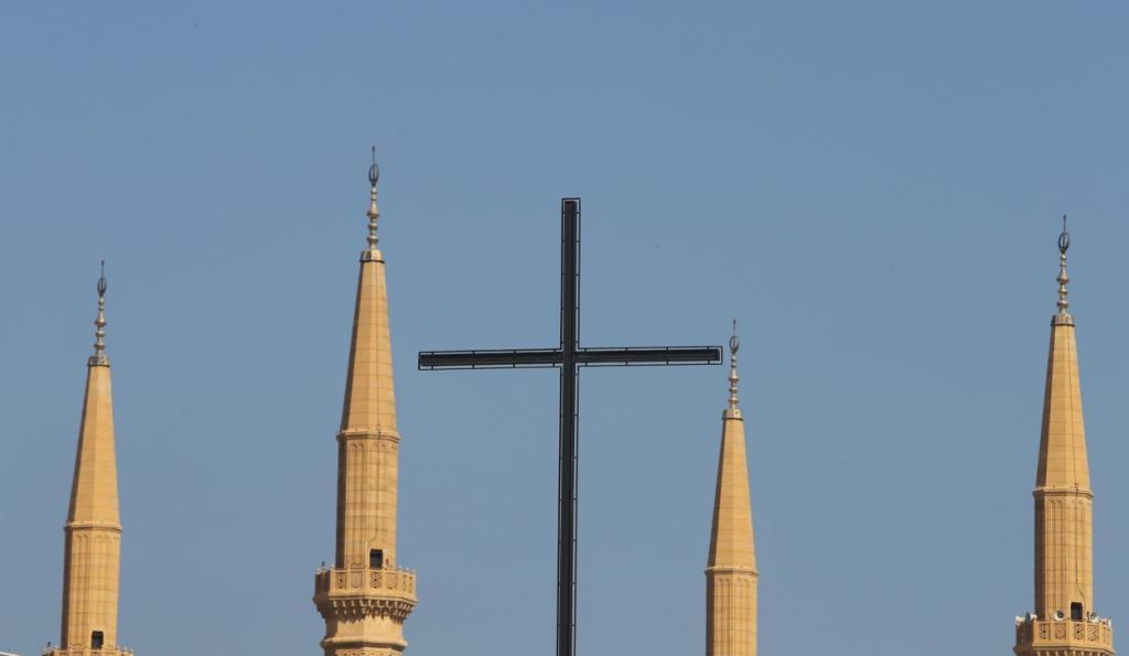 The cross of Beirut's Lazarite Church is flanked by the minarets of the Mohammed al-Amin Mosque in the Lebanese capital's downtown.