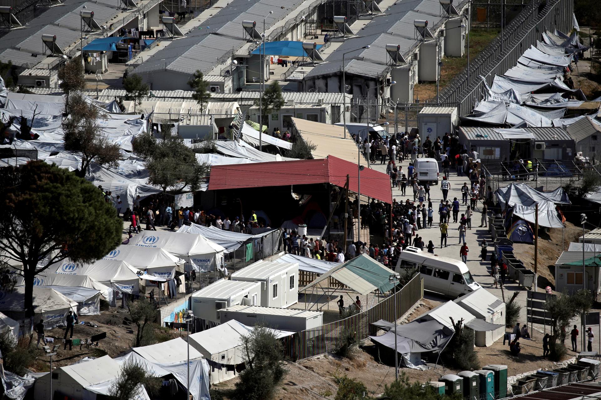 Refugees and migrants line up for food distribution at the Moria migrant camp on the island of Lesbos, Greece October 6, 2016.