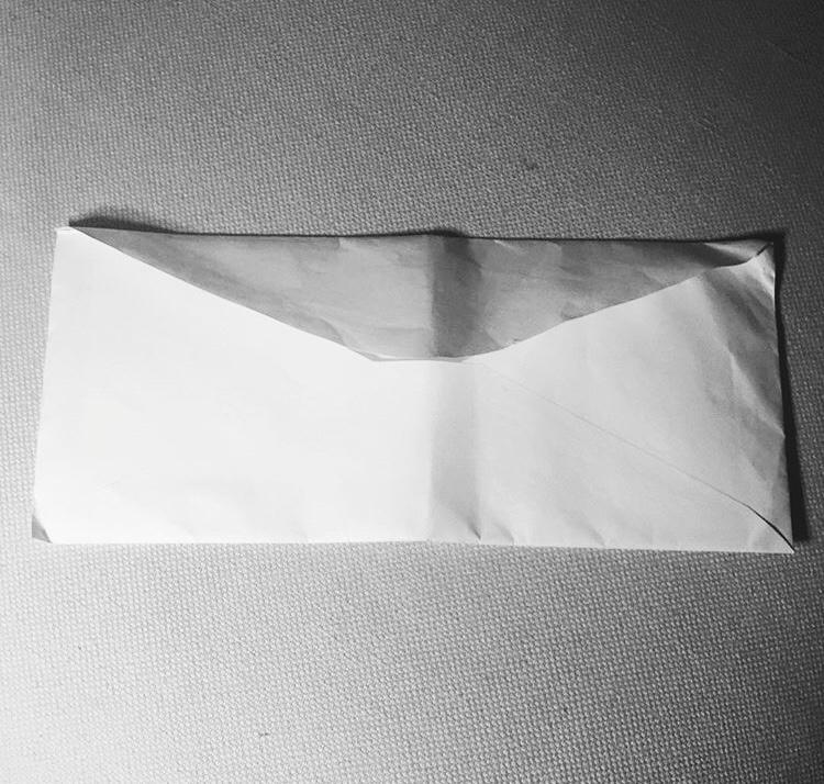 A close up of a white envelope containing a letter.
