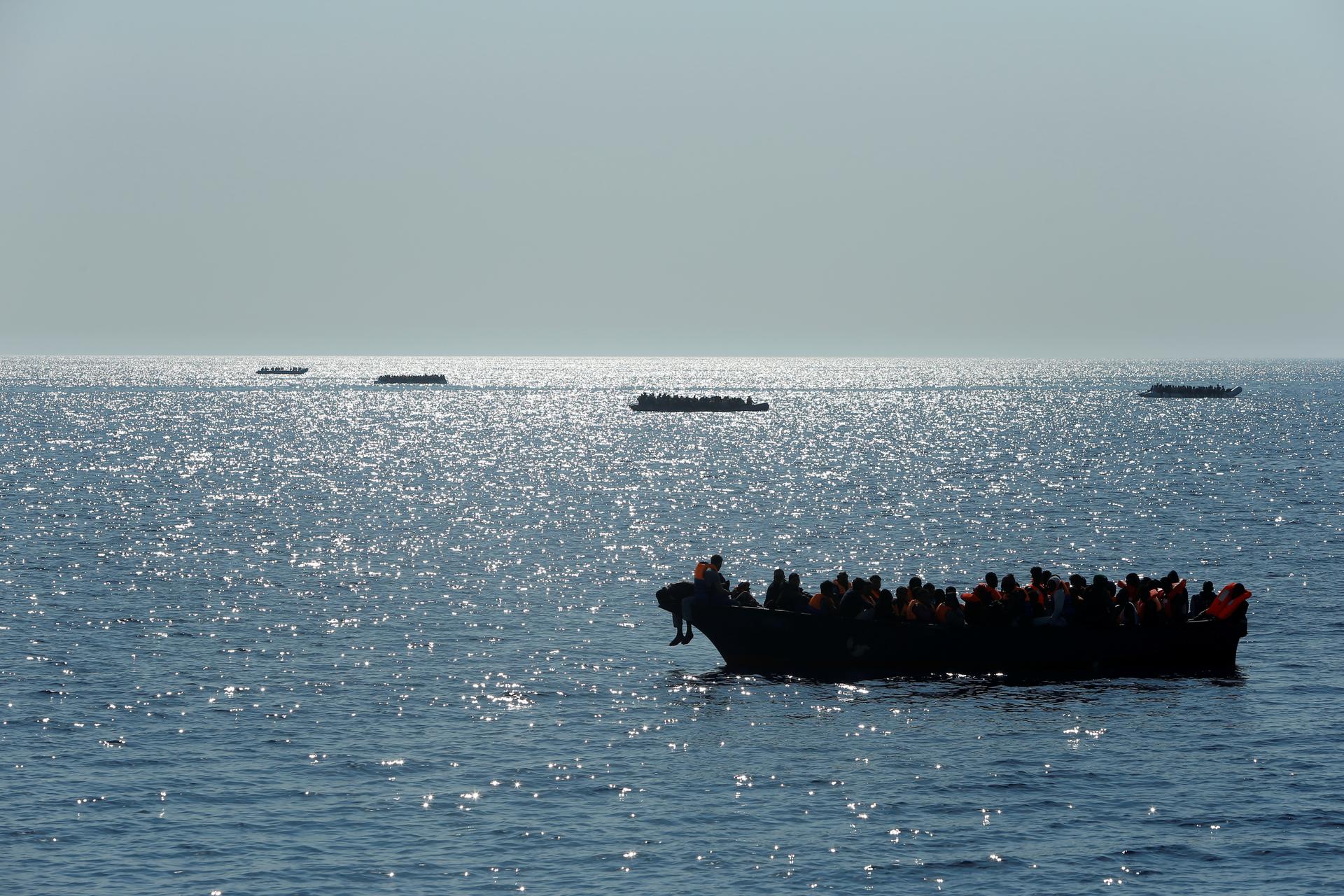 Migrants on wooden boats and rubber dinghies awaiting rescue are seen from the Malta-based NGO Migrant Offshore Aid Station ship Phoenix