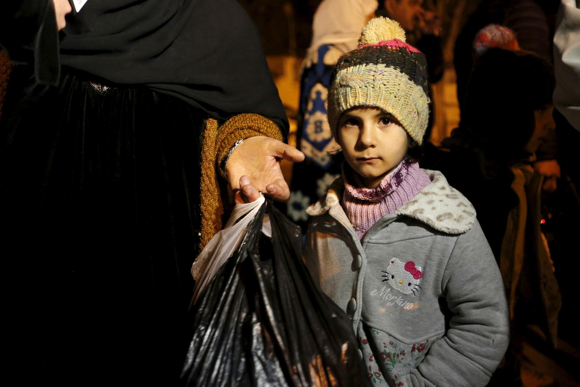 A Syrian girl waits with her family hoping to leave the town of Madaya where thousands have been dying of starvation. Trucks from international relief organizations entered Madaya January 11, 2016 carrying food and medical supplies.
