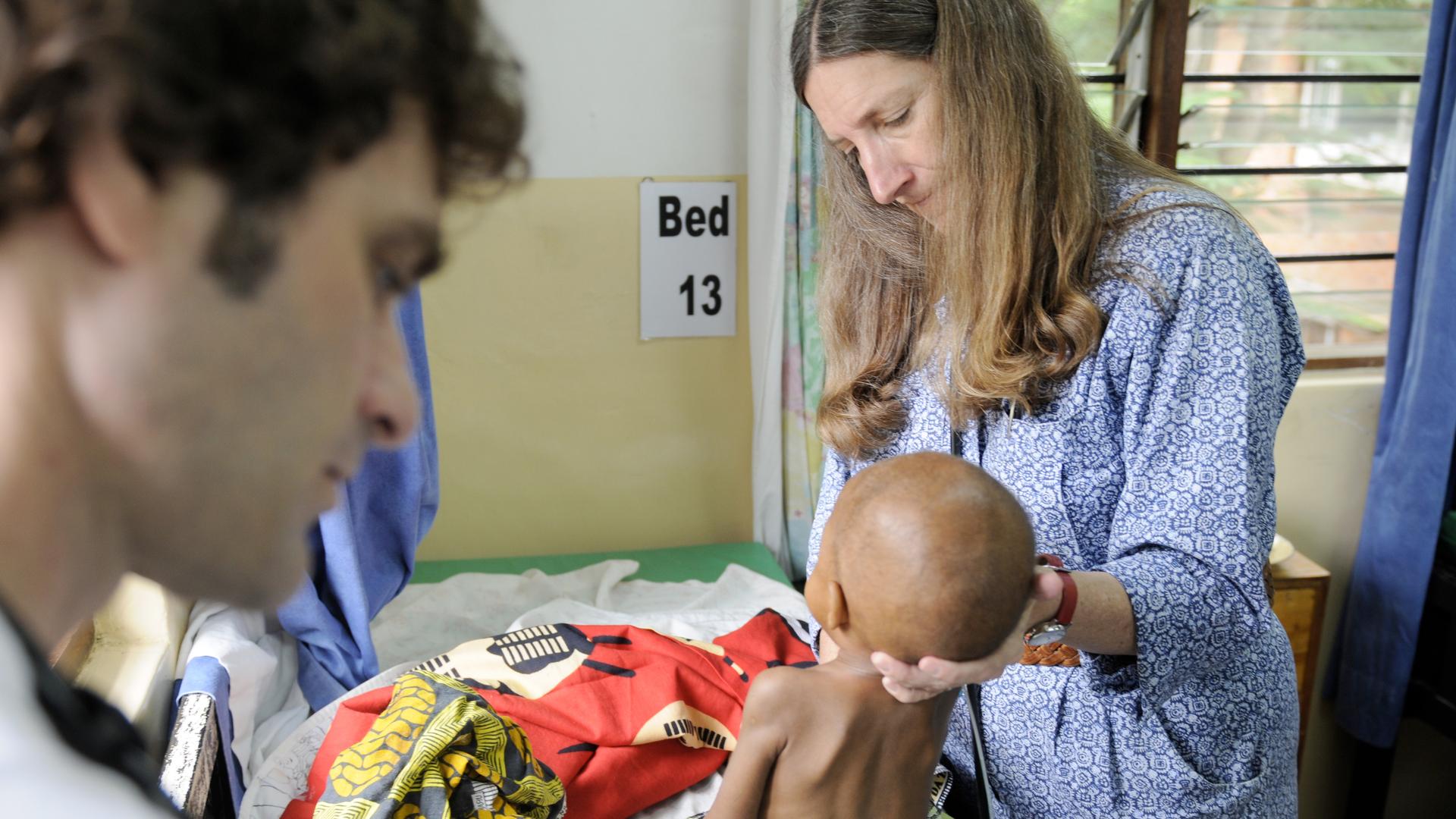 Dr. Terrie Taylor examines a child in the malaria ward of Queen Elizabeth Hospital in Blantyre, Malawi. 