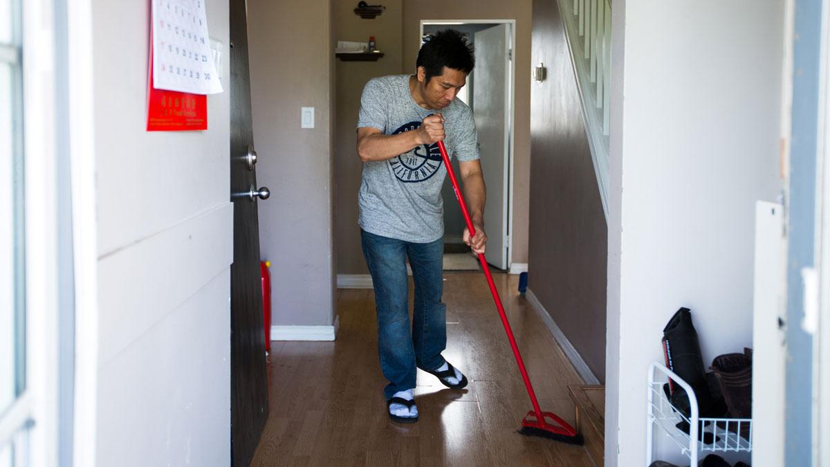 A man sweeps the floor of his house in Alberta, Canada.
