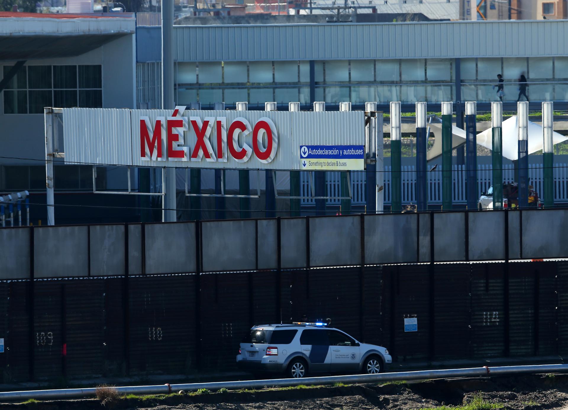 A US border patrol vehicle drives along the border wall between Mexico and the United States