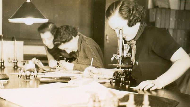 In an archive photo, student Mary Duke Webber uses a microscope at Duke University at some time in the late 1930s.