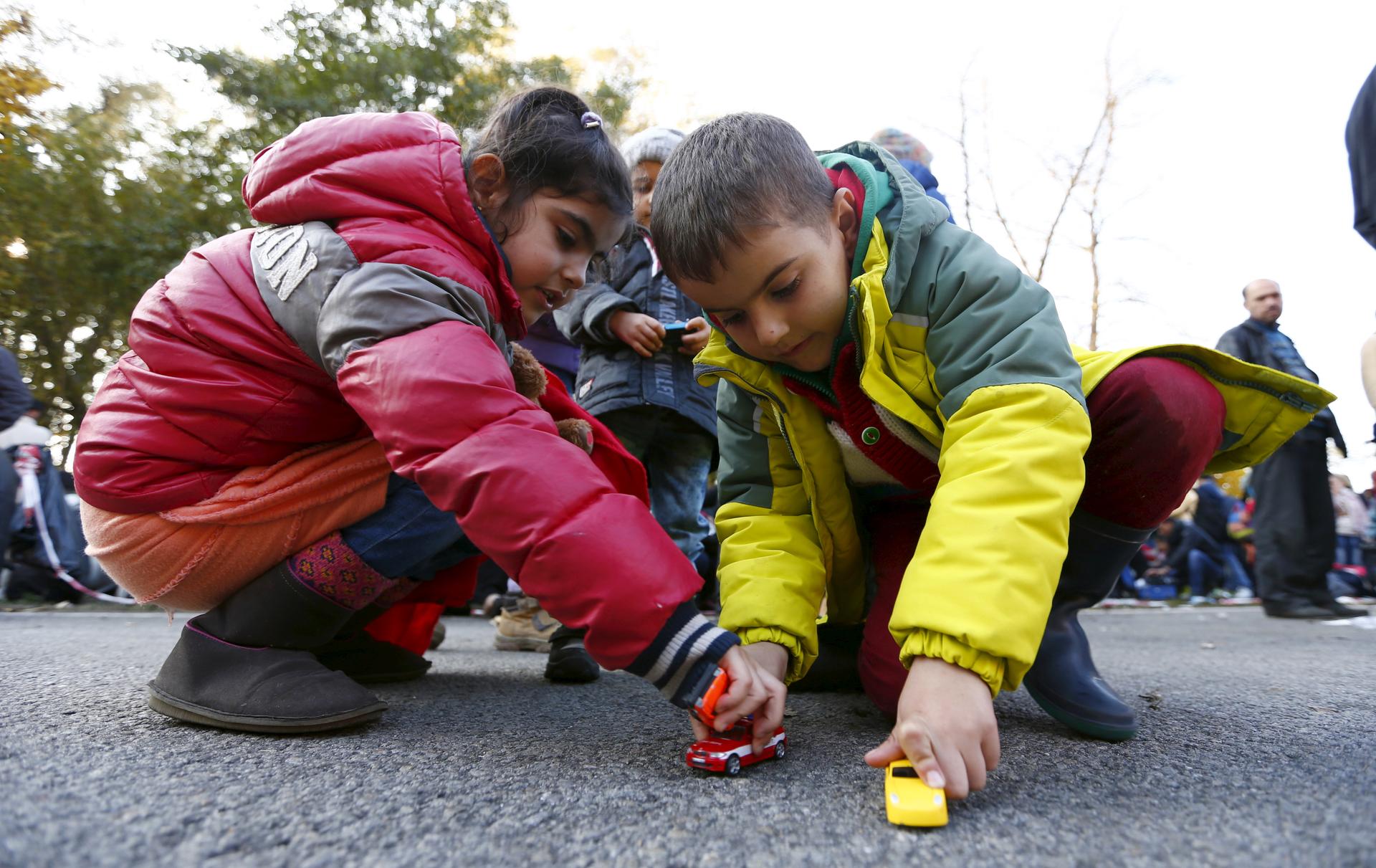 Syrian playmates lay along the street after arriving with their family. Chancellor Angela Merkel was criticized and praised over her management of the refugee crisis. Germany is taking in more migrants than any other EU state.