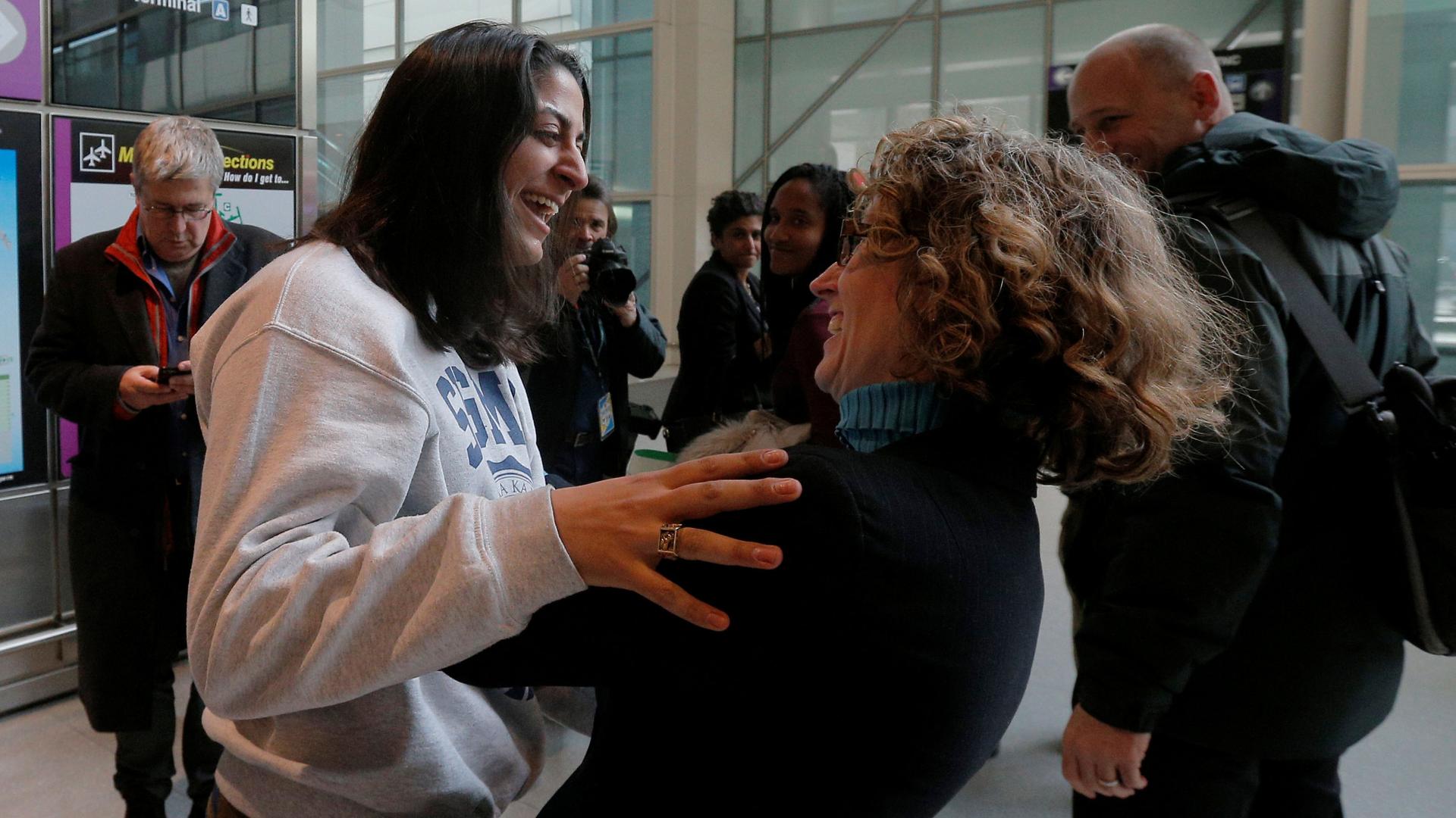 Niki Rahmati, a student at the Massachusetts Institute of Technology (MIT) from Iran, is greeted by immigration attorney Susan Church (R) at Logan Airport in Boston, MA.
