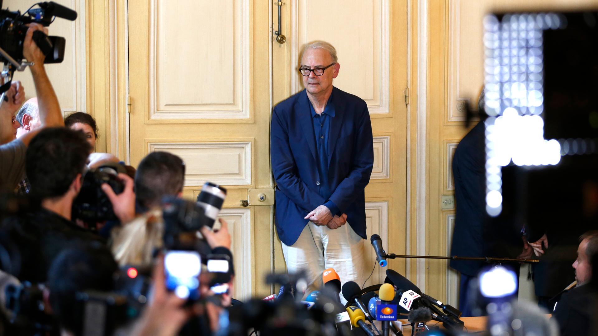 French writer Patrick Modiano poses for journalists in Paris on October 9, 2014, after he was declared the winner of the 2014 Nobel Prize for Literature.
