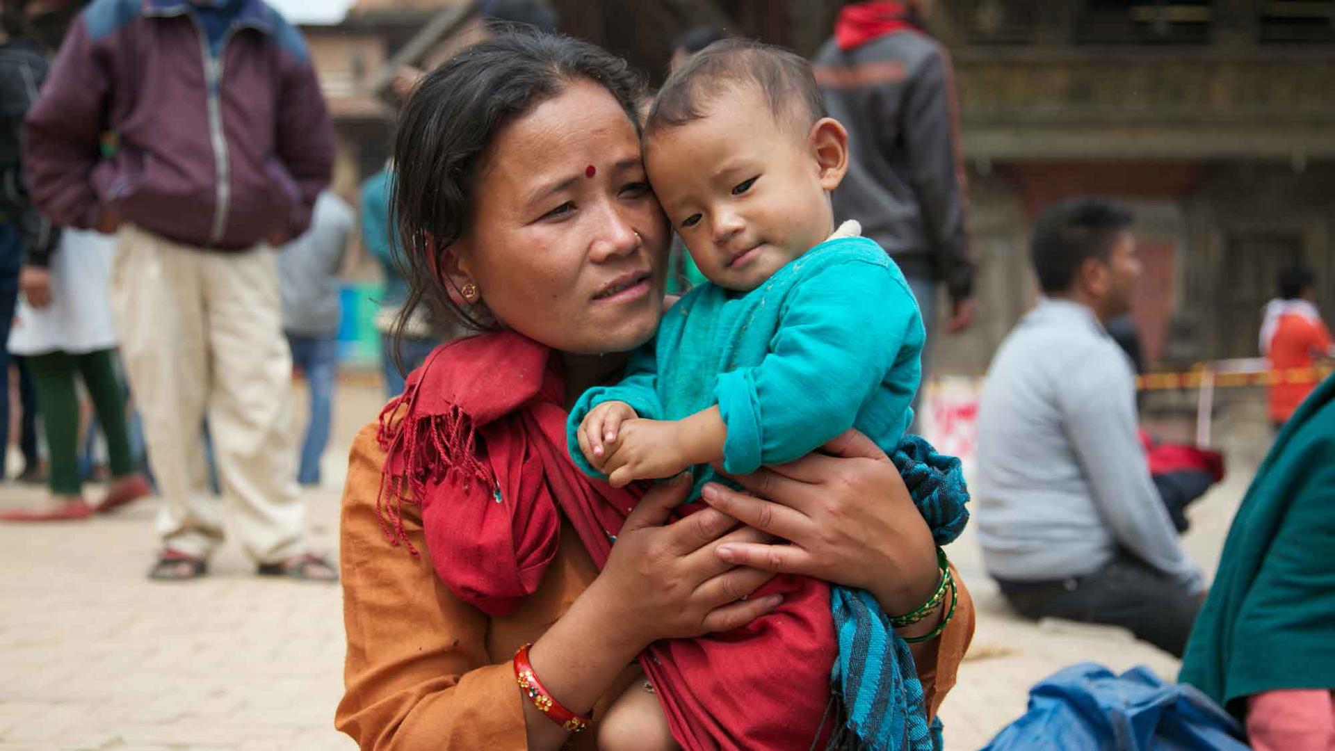 A mother with her son by Patan Durbar Square, a UNESCO World Heritage site, one day after the earthquake destroyed several temples.