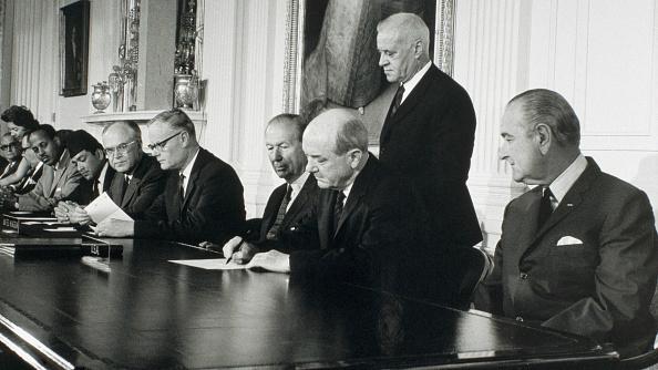 US President Lyndon Johnson looks on as Secretary of State Dean Rusk signs the Treaty for the Non-Proliferation of Nuclear Weapons on July 1, 1968.