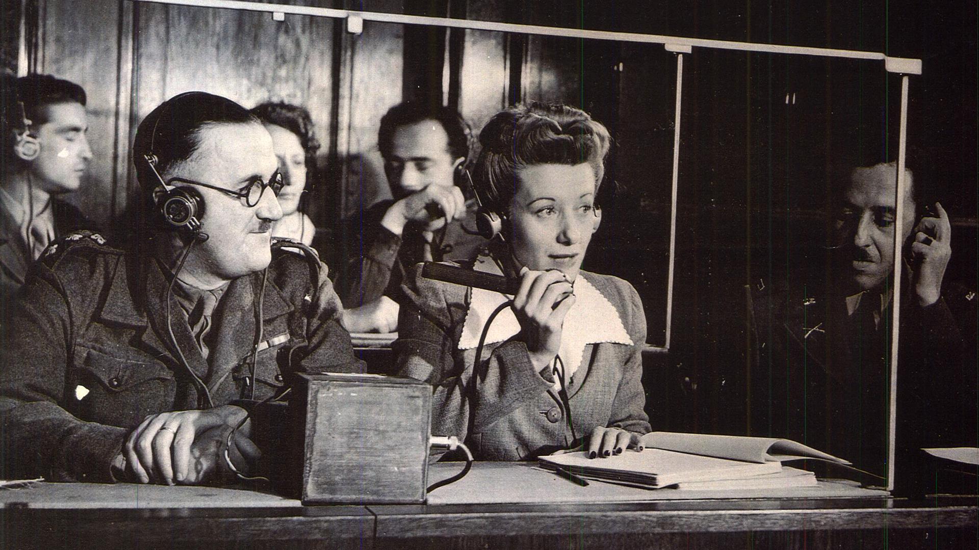 The interpreters' booth at the Nuremberg trials. From left to right: Capt. Macintosh, British Army, translates from French into English; Miss Margot Bortlin, translates from German into English; Lt. Ernest Peter Uiberall, Monitor. 