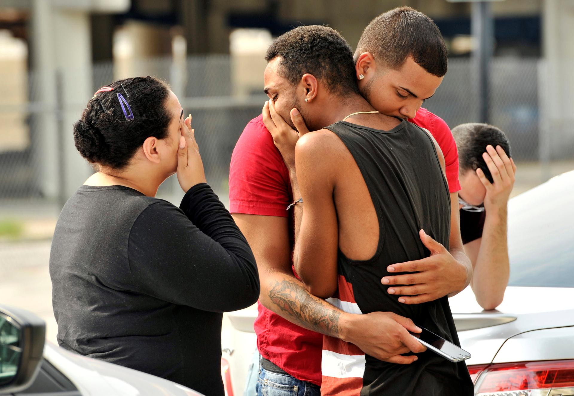 Friends and family members embrace outside the Orlando Police Headquarters
