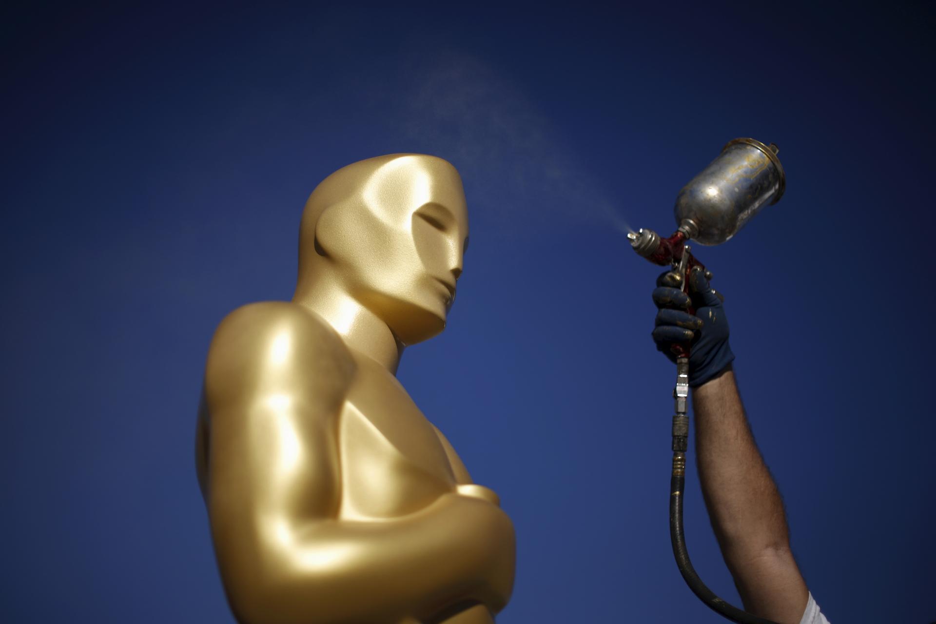 A worker spray paints an Oscar statue outside the Dolby Theatre on Feb. 25, 2016 in preparation for the 88th Academy Awards in Hollywood.