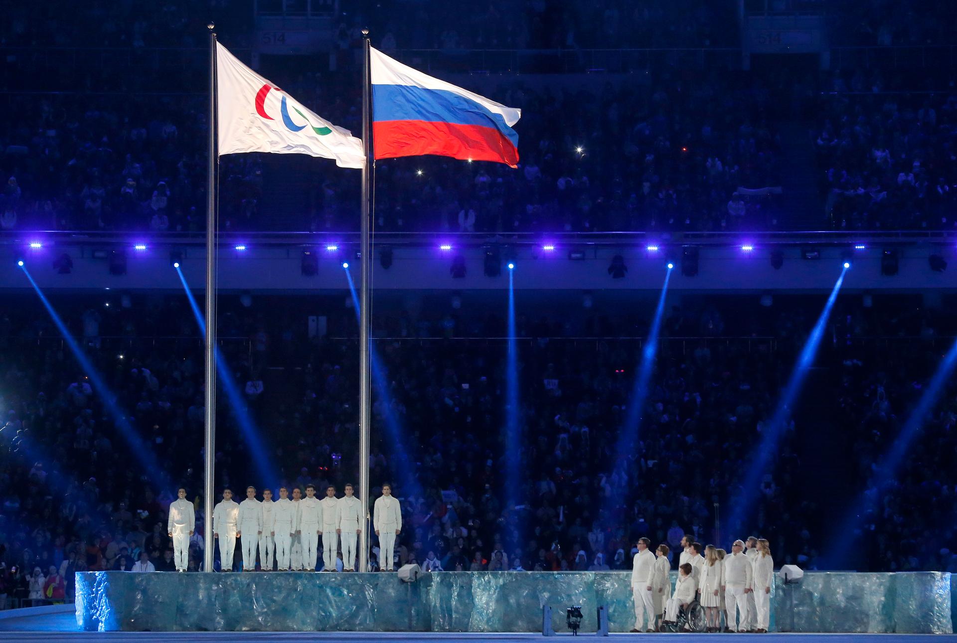 The Paralympic flag, left, is seen beside the Russian national flag during the opening ceremony of the 2014 Paralympic Winter Games in Sochi, March 7, 2014.