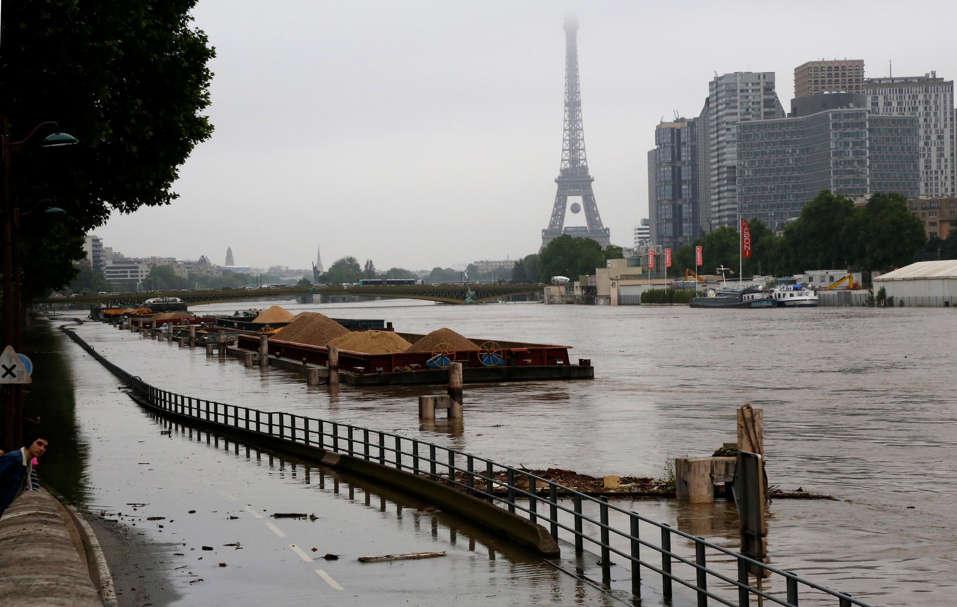 Barges are moored together near the Eiffel Tower